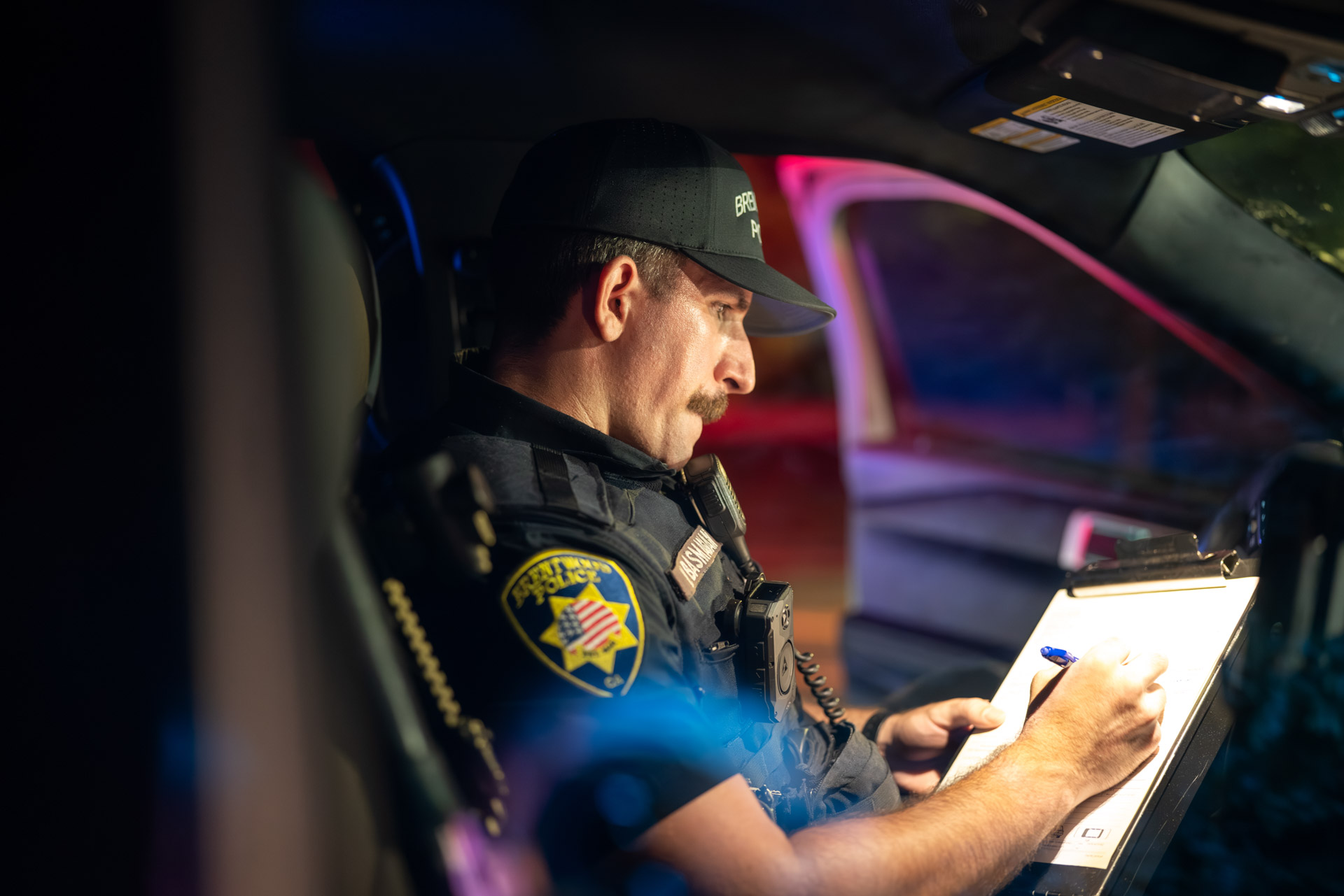 Officer writing a report inside the patrol vehicle